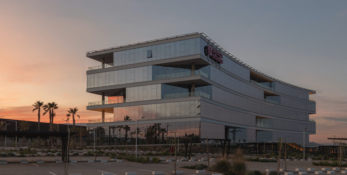 Edificio Avatar al atardecer, con su fachada vidriada curva y palmeras