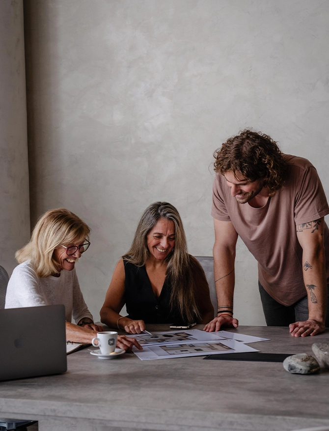 Tres personas revisan planos sobre una mesa de trabajo